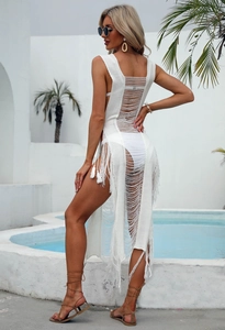 Detail of white crochet beach cover-up featuring open-back knit and fringed tassel hem