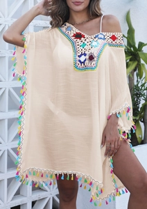 Détail de la broderie crochetée colorée et des pompons vibrants sur la robe de plage d'été
