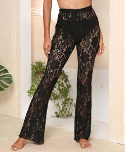Close-up of black floral lace see-through flared trousers with elegant high waist pattern