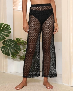 Détail de la texture en dentelle crochetée noire avec motifs floraux ajourés du pantalon