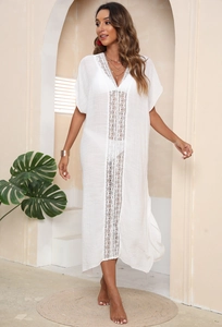 Detailed view of white beach cover-up with intricate lace crochet and V-neck design
