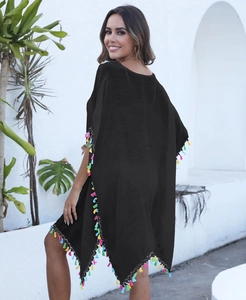 Détail d'un cache-maillot noir avec des finitions à franges colorées et tissu texturé
