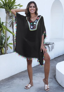 Détail de la broderie ethnique colorée sur l'encolure et franges sur la robe de plage noire