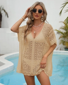 Macro detail of beige crochet hollow-out pattern on a deep V-neck beach cover-up
