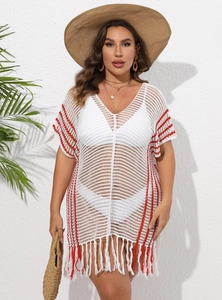 Macro detail of white crochet beach cover-up featuring red vertical stripes and tassels