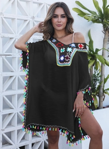 Détail de la robe de plage bohème avec fleurs au crochet et franges multicolores
