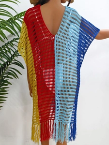 Detailed close-up of knit hollow design and colorful fringe hem on beach cover-up