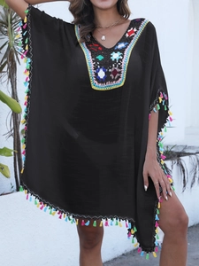 Détails du col en V crocheté coloré et franges multicolores sur le kaftan de plage noir