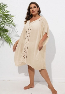 Gros plan sur les détails en crochet beige et le tissu texturé d'un cache-maillot ample