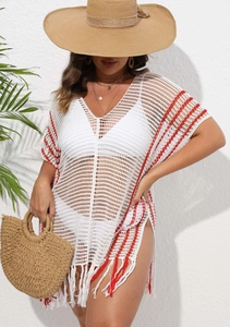 Close-up of crochet beach cover-up featuring red striped patterns and tassel hem detail