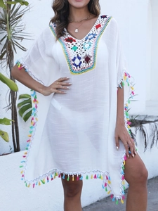 Détail de l'encolure en crochet coloré et pompons sur le cache-maillot de plage