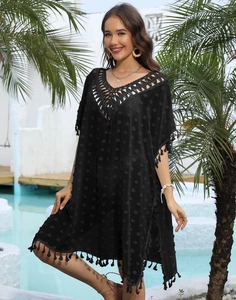 Détail du col en V crocheté et pois texturés sur cache-maillot noir à pompons