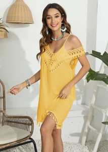Détail du col en V crocheté et de l'ourlet à franges sur une robe de plage jaune vif