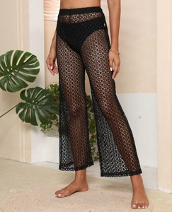 Détail du motif en dentelle noire au crochet sur ce pantalon de plage à taille haute