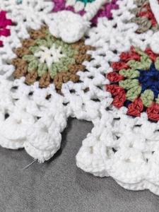 Close-up of handmade crochet granny square beach shorts with colorful flower patterns