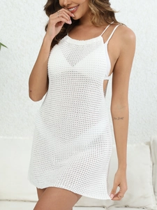 Close-up of intricate crochet texture on a white halter neck mini beach dress cover-up