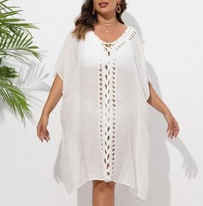 Détail de la tunique de plage blanche en crochet ajouré avec cordon à pompons bohème