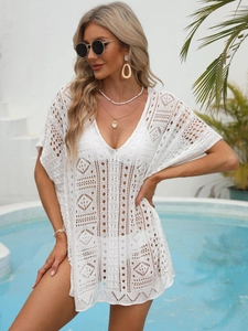 Close-up of white crochet beach cover-up featuring geometric hollow out patterns and V-neck