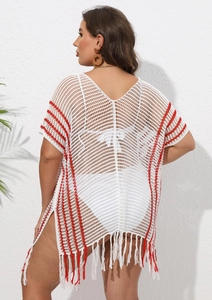 Detail of white crochet beach cover-up featuring red stripes and long fringe tassels