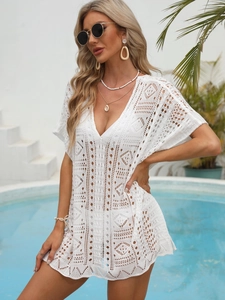 Detail of white crochet knit beach cover-up with intricate geometric hollow patterns