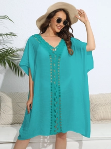 Close-up of turquoise crochet V-neck detailing and textured fabric of the beach cover-up