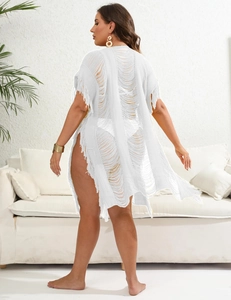 Detail of white knit beach cover-up featuring boho tassels and ripped hollow texture