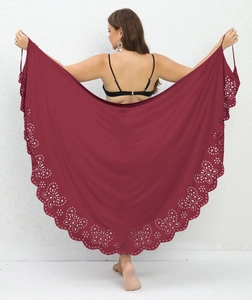 Detail of burgundy beach sarong featuring intricate laser-cut floral patterns on the hem