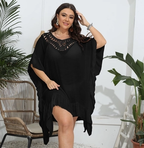 Detail of crochet V-neckline and ruffled hem on a black plus size beach cover-up dress