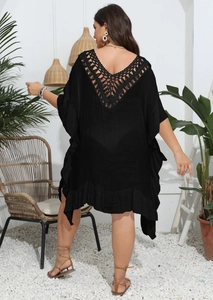 Detail of back V-shaped crochet cutout on black beach cover-up with ruffled edges
