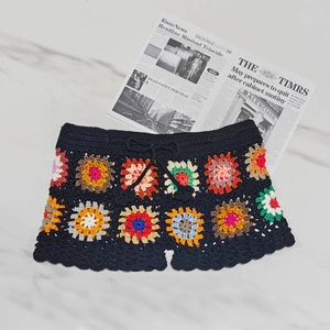 Detailed view of colorful crochet granny square shorts with black base and drawstring waist