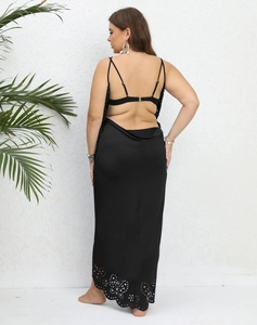 Detail of backless black maxi dress with laser-cut hollow patterns and thin straps