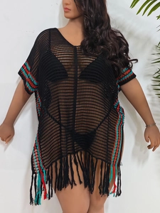 Detail of bohemian crochet beach cover-up featuring colorful stripes and long tassels