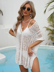 Close-up of bohemian white crochet beach cover-up with intricate geometric knit textures