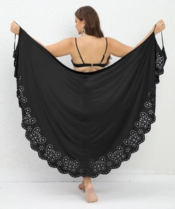 Detail of black beach sarong featuring intricate laser-cut floral patterns on lightweight fabric