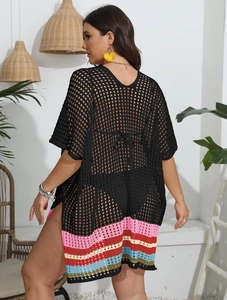 Close-up of black crochet beach cover-up with colorful striped hem and hollow knit detail