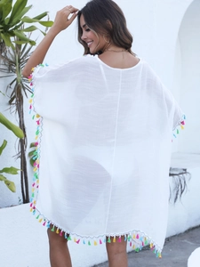 Détail d'un cache-maillot de plage blanc avec bordures à franges colorées au dos