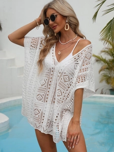Close-up of white crochet beach cover-up featuring geometric hollow out patterns and V-neck