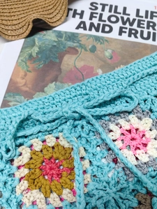 Handmade crochet beach shorts with colorful granny square patterns and blue drawstring ties