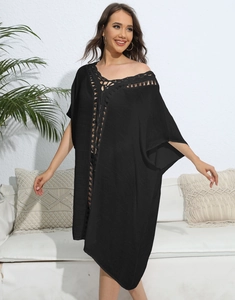 Detail of bohemian black beach cover-up featuring intricate crochet lace and textured fabric