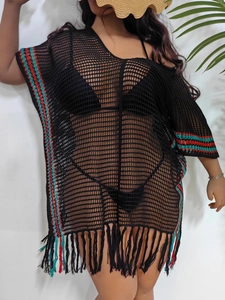 Detail of black crochet beach cover-up featuring colorful striped hem and long fringe