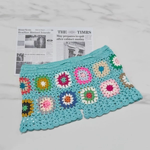 Detailed close-up of handmade crochet beach shorts with colorful granny square patterns