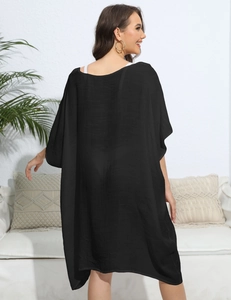 Detail of loose black beach cover-up with textured fabric and batwing sleeve style