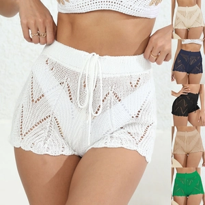 Dettaglio di pantaloncini da spiaggia all'uncinetto bohémien con motivi a onde e coulisse
