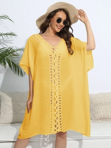 Close-up of bright yellow crochet knit texture and geometric hollow patterns on beach cover-up