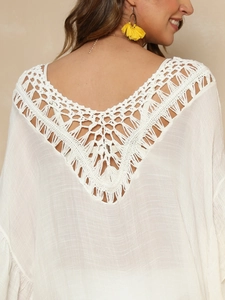Gros plan détaillé du motif crochet évidé blanc au dos de cette robe de plage légère