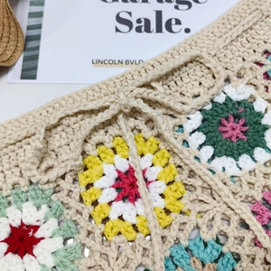 Detail of colorful crochet granny squares and drawstring on handmade beach shorts