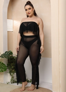 Dettaglio del set da spiaggia in rete nera con crop top a balze e pantaloni a zampa