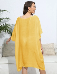 Detail of loose yellow kaftan beach cover-up featuring semi-transparent chiffon fabric