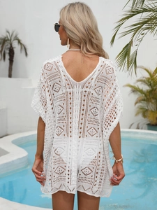 Close-up of the intricate white crochet pattern and hollow knit detail on this beach cover-up