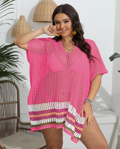 Detailed close-up of pink crochet beach cover-up with multi-colored striped fringe hem